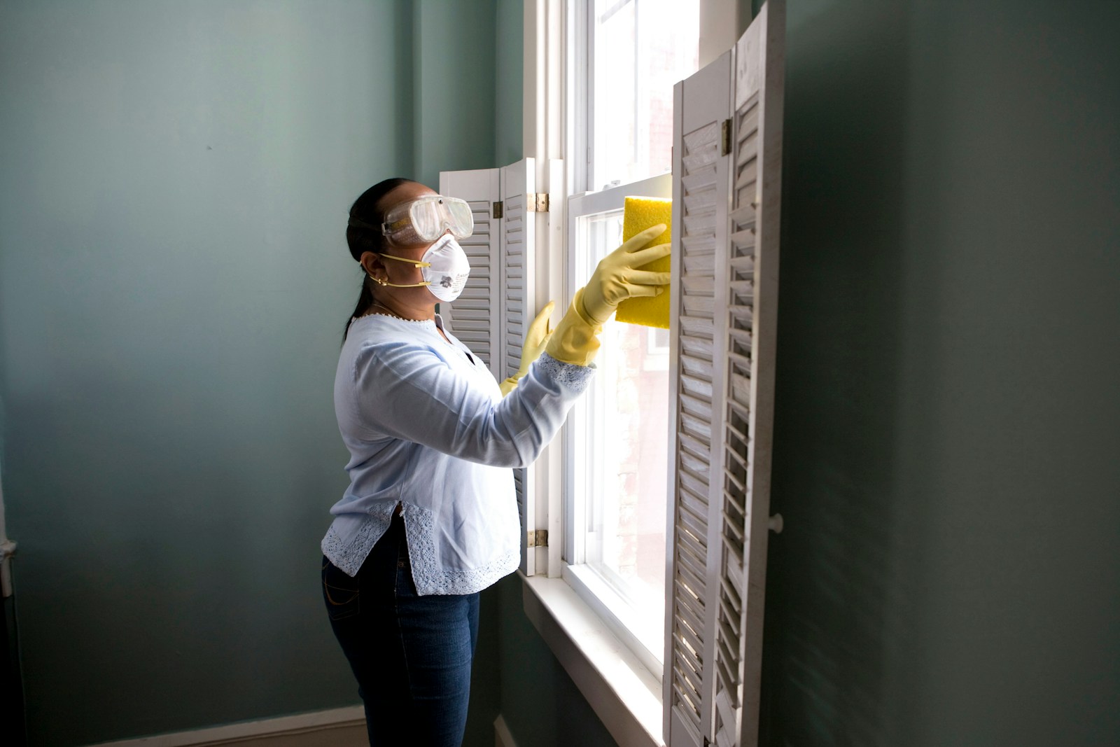 Professional cleaner in uniform cleaning a modern kitchen countertop