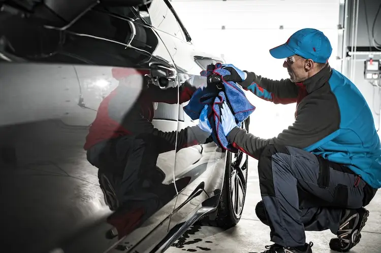 Professional car valeter detailing luxury vehicle exterior